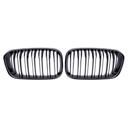 Zwei glänzend schwarze Frontgrills werden nebeneinander auf weißem Hintergrund gezeigt. Jeder RSHOP Frontgrill Glänzend Schwarz für BMW 1er Serie F20 (2015-2017) verfügt über eine Reihe vertikaler Lamellen, die in einem abgerundeten rechteckigen Rahmen eingeschlossen sind und ein glänzendes Finish aufweisen.